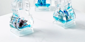 Macro view of blue liquid violin ornament with dolphin scenery and glitter effects