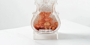 Macro detail of violin ornament with golden sand and Never Ending Love engraving