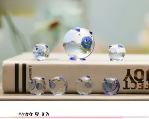 Macro view of crystal glass pig figurines with blue details displayed on white books
