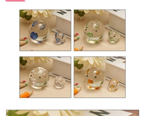 Close-up of glass pig figurines in four vibrant colors on a cozy beige fabric background