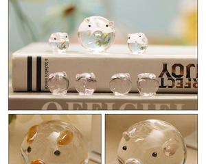 Macro detail of hand-blown crystal glass pigs showing transparency and smooth texture