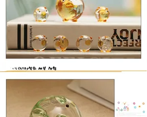 Detailed view of handmade glass pig figurines with gold foil accents and warm amber tones