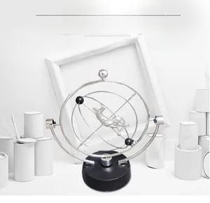 Close-up of rotating silver metal astronaut rings on a black base for modern desk decor