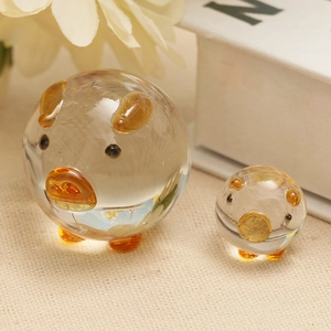 Pair of decorative transparent crystal glass pig ornaments with amber accents for office desks