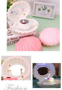 Close-up of shell-shaped music box with spinning ballerina, heart mirror and LED lights