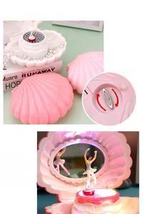Detailed view of pink shell music box with ballet dancer and inner storage mirror