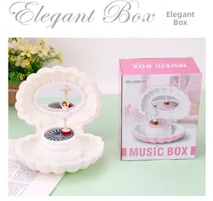 Shell music box with dancing ballerina and colorful lights in elegant gift packaging