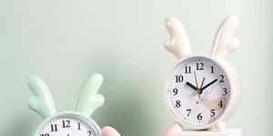 Close-up of cute cartoon reindeer alarm clocks in mint green and beige colors