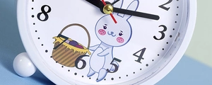 Detail of white rabbit alarm clock face with black numerals and a red second hand