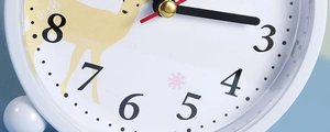 Detailed macro view of white alarm clock dial with cartoon reindeer and red second hand