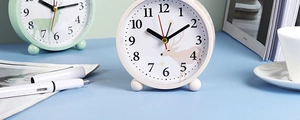 Close-up of minimalist round alarm clock featuring a reindeer illustration and numerals