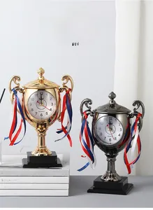 Detail view of trophy alarm clocks in gold and gunmetal finish with elegant ribbons