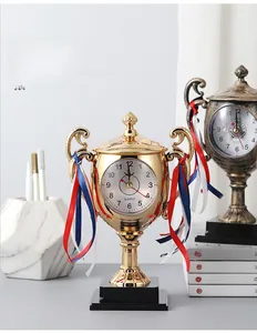 Detailed close-up of a trophy alarm clock with golden finish and quartz clock face
