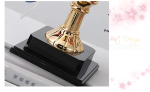 Macro shot of trophy alarm clock base featuring golden metal pillar and black foundation