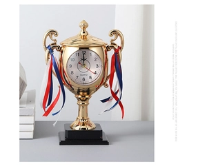 Detail of creative trophy desk clock with gold finish, quartz movement, and ribbons