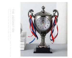 Macro shot of creative trophy-shaped desk clock with elegant silver finish and ribbon