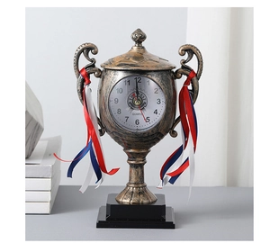Detail of vintage bronze trophy desk clock with The Best text and decorative ribbons