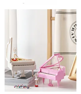 Detail of miniature piano music boxes in pink and white with dancing ballerina figures