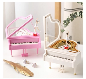 Detail of piano music box with rotating ballerina and golden floral patterns inside