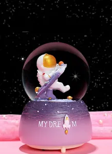 Detail of astronaut crystal ball with glowing snow globe effect and pink base