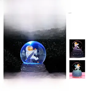 Detailed view of astronaut crystal ball with glowing blue light and My Dream base
