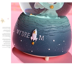 Detail of blue astronaut crystal ball base with MY DREAM text and small rocket