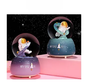 Detailed view of astronaut crystal ball music boxes with colorful gradient bases