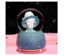 Detail of astronaut crystal ball featuring inner resin figure and starry blue base
