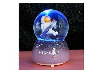 Macro shot of astronaut crystal ball with glowing blue LED light and MY DREAM base