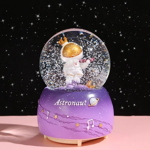 Astronaut snow globe music box with violin player and purple planet themed base