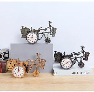Dettaglio degli orologi da tavolo a moto retrò con portapenne in tre colori metallici