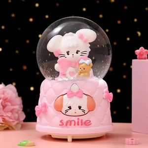 Close-up of a pink musical snow globe featuring a cute bunny and quilted pattern base