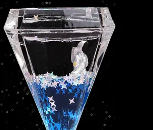 Vue rapprochée d'un sablier liquide en diamant avec astronaute et paillettes d'étoiles