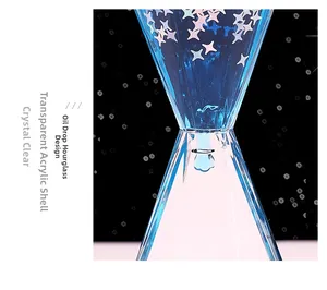 Détail macro du liquide bleu s'écoulant avec des paillettes étoiles dans un sablier
