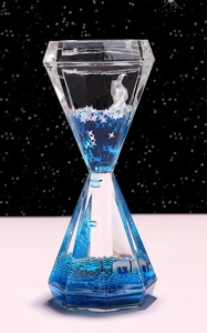 Makroansicht der diamantförmigen Sanduhr mit Astronautenfigur und silbernen Sternchen