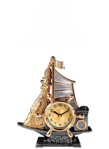 Detail of vintage sailboat desk clock with golden helm dial and nautical elements