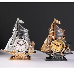 Detailed close-up of retro sailboat alarm clocks with golden hulls and nautical rudders