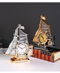 Detailed macro view of vintage sailing ship desk alarm clocks in gold and silver plating