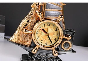 Close-up of vintage golden sailboat alarm clock with detailed nautical steering wheel