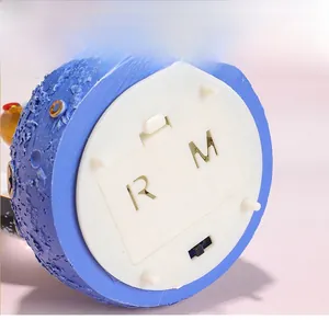Detail of blue astronaut music box base with moon crater texture and power switch