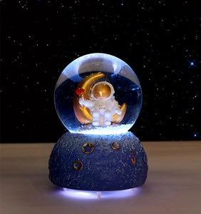 Close-up of an astronaut on a golden moon inside a glowing star-themed crystal ball