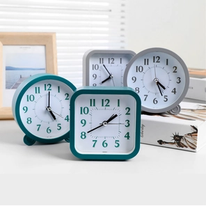 Detail of minimalist desk clocks in round and square shapes, teal and grey color set