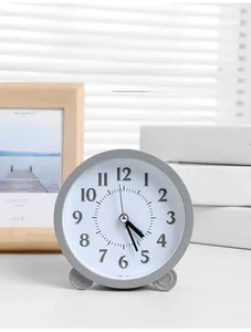 Detail of grey Nordic minimalist round alarm clock with black 3D Arabic numerals