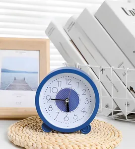 Detailopname van een blauwe stille bureauklok op een houten nachtkastje in huisstijl