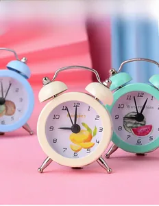 Macro view of mini metal twin bell alarm clocks in pastel blue, cream, and mint green