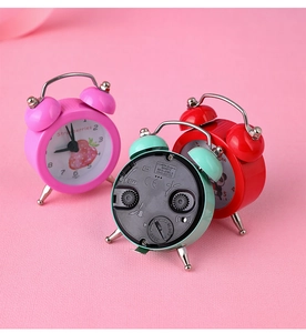 Detailed view of the back of a mini alarm clock showing battery compartment and setting knobs