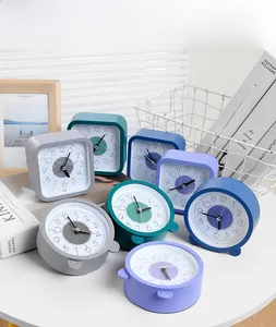 Minimalistische stille wekkers in pastelkleuren gerangschikt met woondecoraties