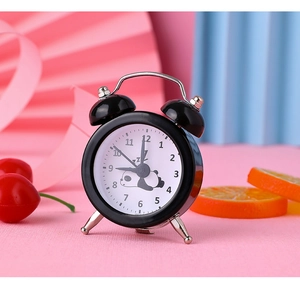 Detail of a mini black twin bell alarm clock featuring a cute panda face and bold numbers