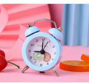 Detail of light blue twin bell alarm clock featuring a realistic kiwifruit dial pattern