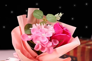 Close-up of pink soap rose bouquet with faux greenery and shimmering starlight background